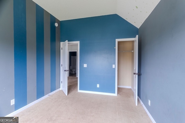 unfurnished bedroom featuring a closet, carpet floors, and vaulted ceiling