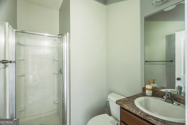 bathroom featuring vanity, toilet, a shower with door, and a textured ceiling