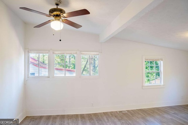 empty room with ceiling fan, lofted ceiling with beams, a textured ceiling, and light hardwood / wood-style floors