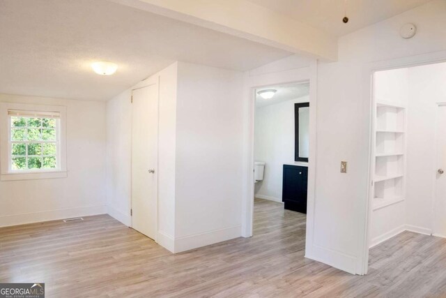 empty room featuring lofted ceiling and light hardwood / wood-style flooring