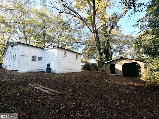 view of home's exterior featuring central AC and an outbuilding