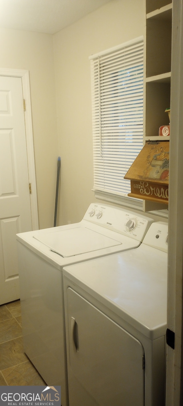 washroom with washing machine and clothes dryer and light tile patterned floors