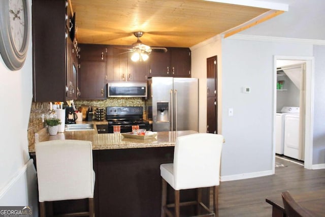 kitchen featuring stainless steel appliances, a kitchen breakfast bar, kitchen peninsula, dark brown cabinets, and ornamental molding