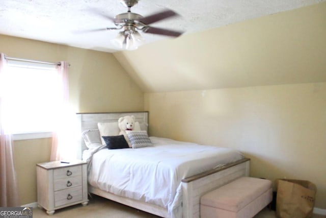 bedroom featuring a textured ceiling, ceiling fan, and lofted ceiling