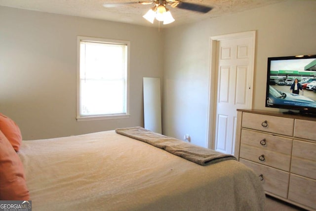 bedroom with ceiling fan and a textured ceiling