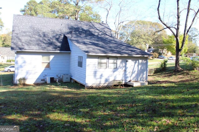 view of side of home featuring a yard and central AC