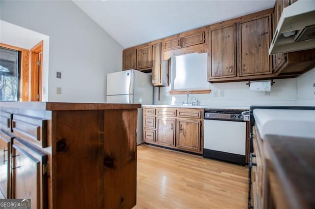 kitchen with light wood-type flooring, white appliances, and vaulted ceiling