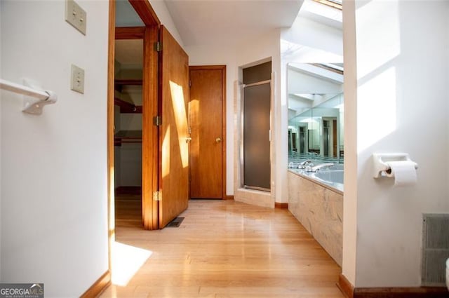 bathroom featuring wood-type flooring and separate shower and tub