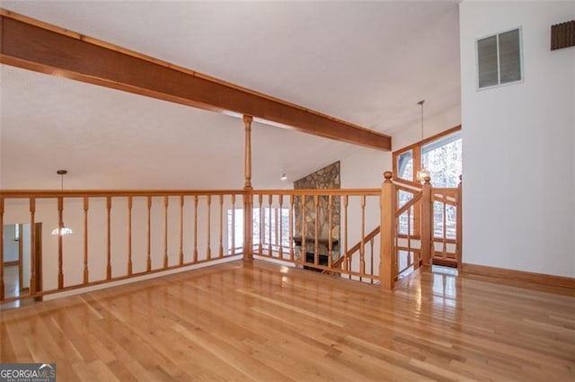 interior space featuring vaulted ceiling with beams and light hardwood / wood-style floors