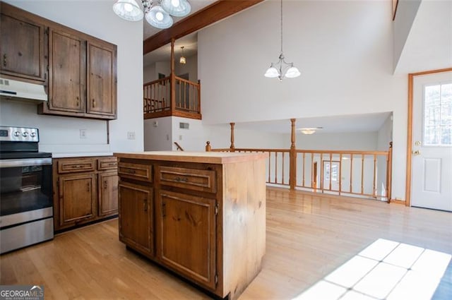 kitchen featuring light wood-type flooring, decorative light fixtures, stainless steel range oven, and a notable chandelier