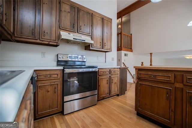 kitchen featuring stainless steel electric range oven and light hardwood / wood-style floors