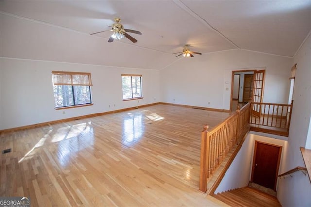 empty room featuring light hardwood / wood-style flooring, vaulted ceiling, and ceiling fan