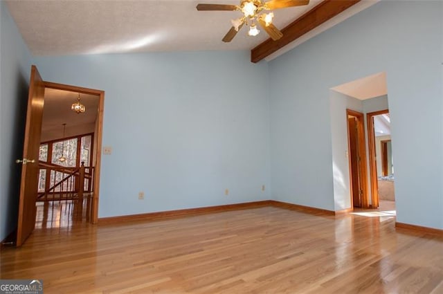 spare room featuring ceiling fan with notable chandelier, lofted ceiling with beams, and light hardwood / wood-style floors