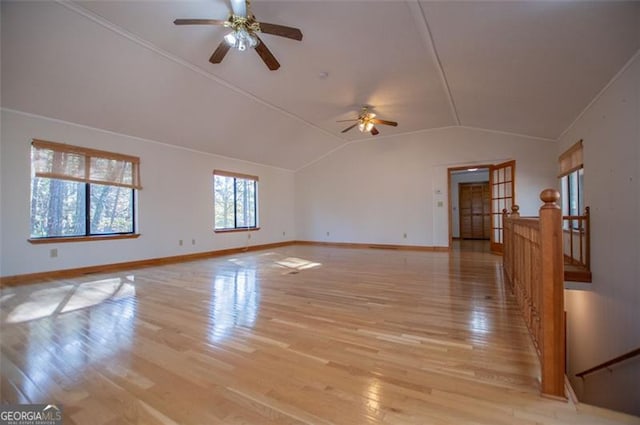 empty room with ceiling fan, light hardwood / wood-style flooring, and vaulted ceiling