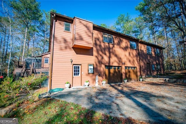 back of house with a garage and a wooden deck