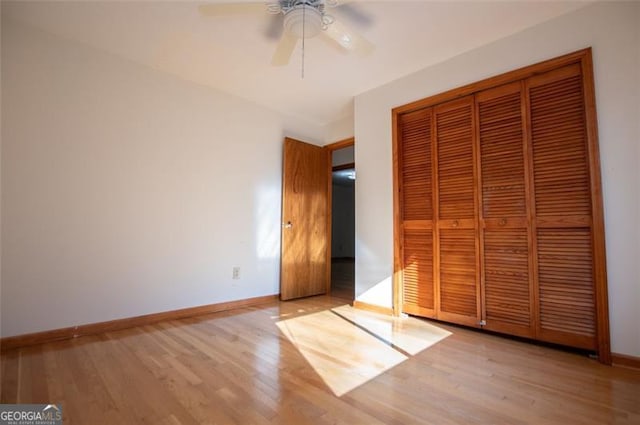 unfurnished bedroom with light hardwood / wood-style flooring, a closet, and ceiling fan