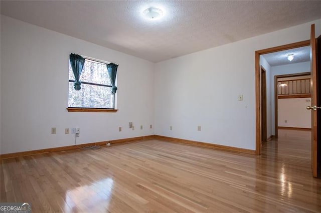 unfurnished room featuring wood-type flooring and a textured ceiling