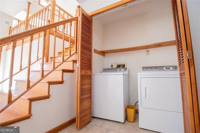 laundry area featuring light tile patterned floors and washer and clothes dryer