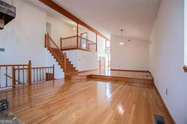 unfurnished living room featuring hardwood / wood-style floors and high vaulted ceiling