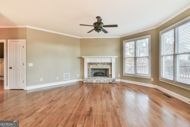 unfurnished living room with a fireplace, light wood-type flooring, ceiling fan, and ornamental molding