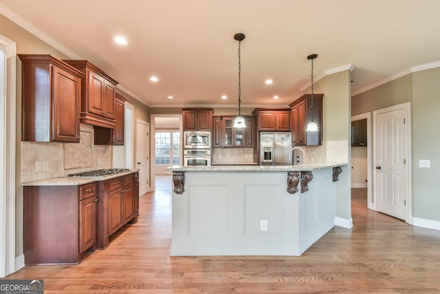 kitchen with light hardwood / wood-style flooring, light stone countertops, ornamental molding, appliances with stainless steel finishes, and decorative light fixtures