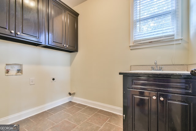 washroom with hookup for an electric dryer, washer hookup, cabinets, sink, and light tile patterned flooring