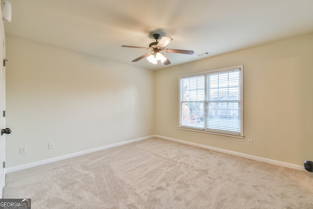 empty room with ceiling fan and light colored carpet