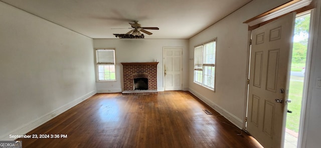 unfurnished living room featuring ceiling fan, a fireplace, and dark hardwood / wood-style floors