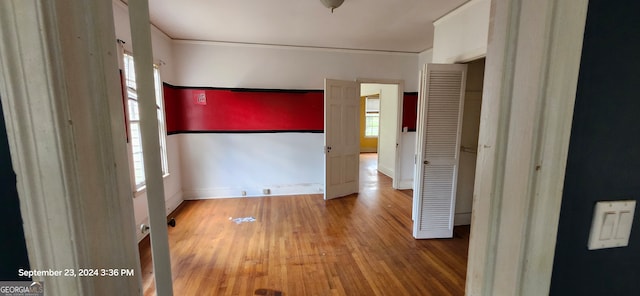 unfurnished bedroom with hardwood / wood-style flooring and ornamental molding