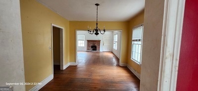 hall featuring a chandelier and dark wood-type flooring