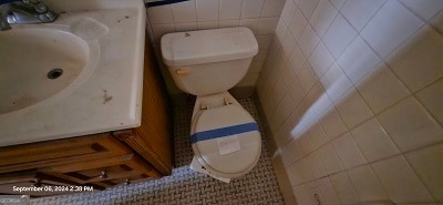 bathroom with tile patterned floors, sink, toilet, and tile walls