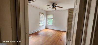 empty room with wood-type flooring and ceiling fan