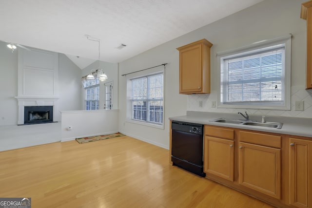 kitchen featuring a fireplace, dishwasher, sink, a chandelier, and hanging light fixtures