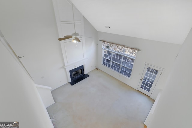 carpeted living room featuring a fireplace, high vaulted ceiling, and ceiling fan