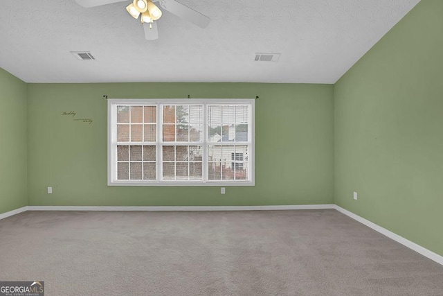 carpeted empty room featuring a textured ceiling and ceiling fan