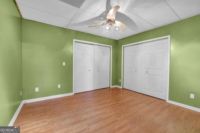 unfurnished bedroom with ceiling fan, a paneled ceiling, and light hardwood / wood-style flooring