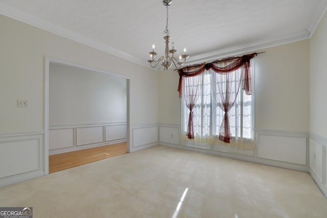 empty room featuring ornamental molding, carpet floors, and an inviting chandelier