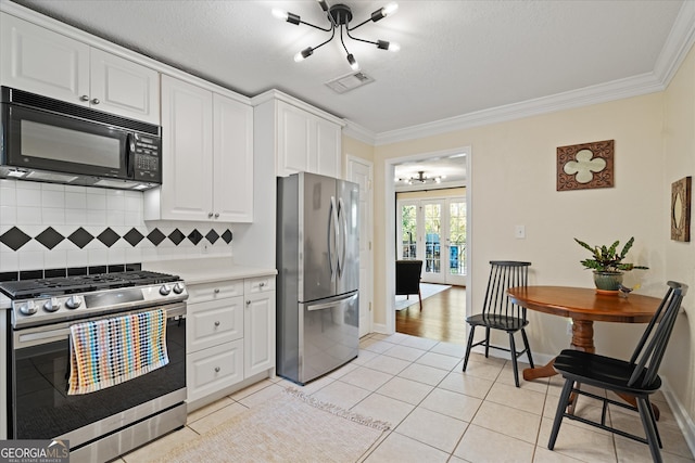 kitchen with decorative backsplash, appliances with stainless steel finishes, ornamental molding, white cabinets, and light tile patterned flooring