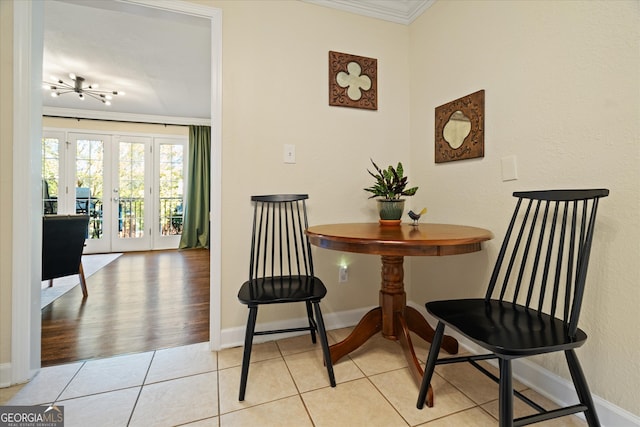 dining space featuring french doors, crown molding, and light tile patterned flooring