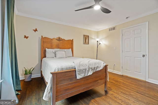 bedroom with dark hardwood / wood-style flooring, ceiling fan, and crown molding