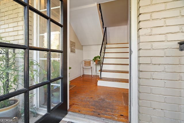 stairway featuring hardwood / wood-style flooring and vaulted ceiling