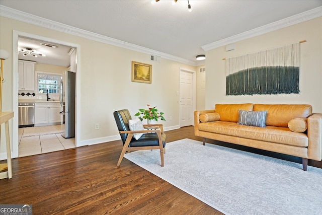 living room featuring sink, light hardwood / wood-style flooring, and ornamental molding