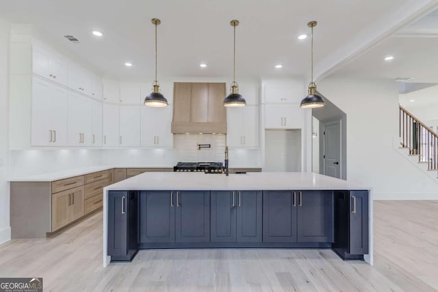 kitchen with white cabinetry, hanging light fixtures, and a spacious island