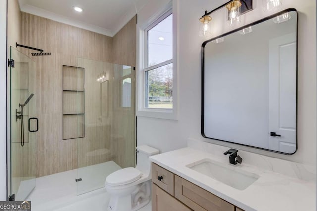 bathroom with walk in shower, crown molding, vanity, and toilet