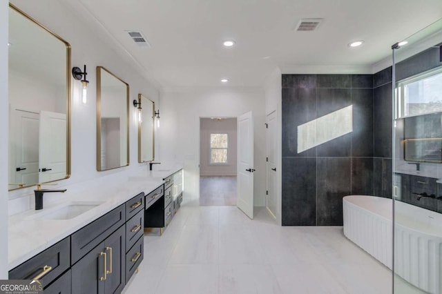 bathroom featuring vanity, a tub to relax in, plenty of natural light, and tile walls