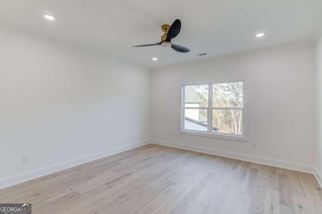 spare room with ceiling fan, light wood-type flooring, and ornamental molding