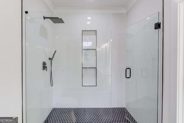 bathroom with crown molding and a shower with shower door