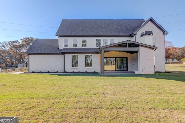 back of property with a patio area and a yard