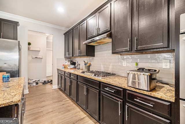 kitchen featuring light stone countertops, crown molding, appliances with stainless steel finishes, and light hardwood / wood-style flooring