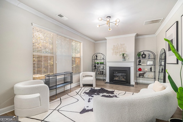 living room featuring wood-type flooring, an inviting chandelier, and ornamental molding